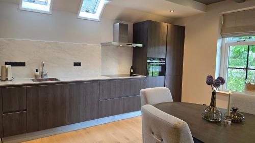 a kitchen with a table and a sink and a counter at Vakantiewoning In de boerderij in Arum