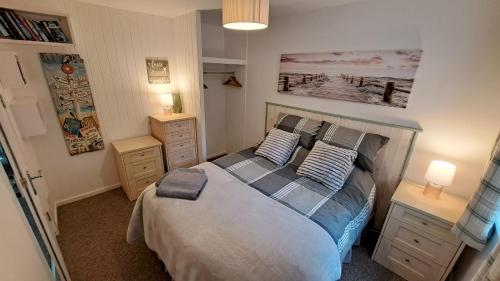 a bedroom with a bed with two night stands and two lamps at Oak Bungalow in Carbis Bay