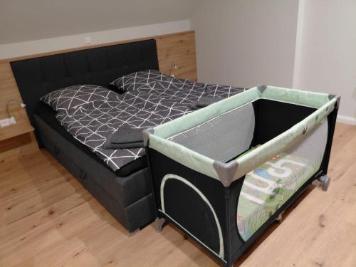 a black bed with a black frame with a crib at Ferienwohnung Alte Schule in Lonnerbecke