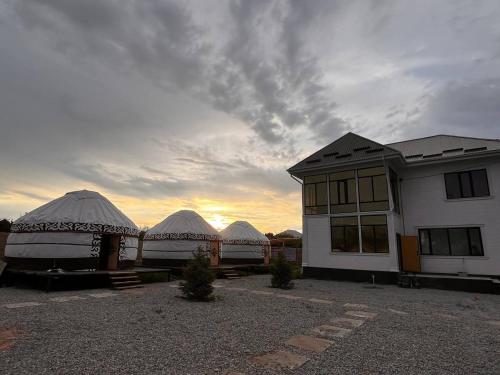 a group of domes with the sunset in the background at Yurt house in Tong