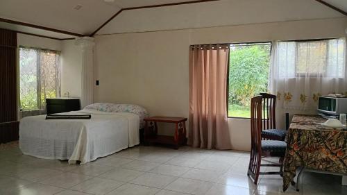 a bedroom with a bed and a tv and windows at Little Home in General Viejo