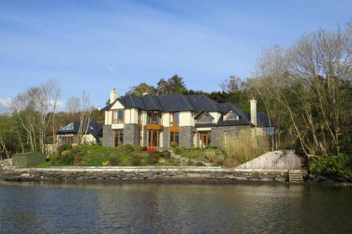 a large house on the side of a body of water at Seafort Luxury Hideaway in Bantry