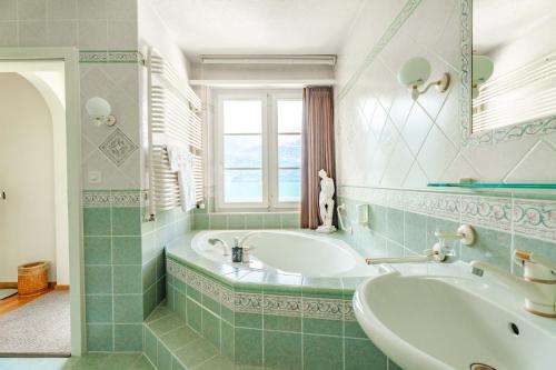 a bathroom with a tub and a sink at Seehotel Schwert in Gersau
