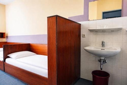 a bathroom with a bed and a sink at Der Sunderhof in Seevetal