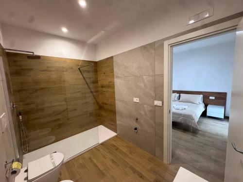 a bathroom with a shower and a toilet and a bed at Les chambres de Nancy in Contursi Terme