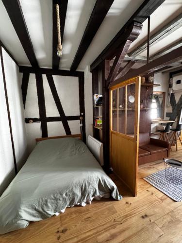 a bedroom with a bed in a room with a table at T2 L'Atypique au pied de la cathédrale in Bourges
