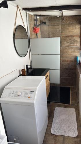 a washing machine in a kitchen with a mirror at T2 L'Atypique au pied de la cathédrale in Bourges