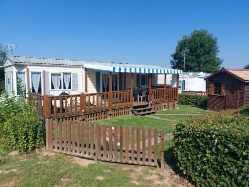 a house with a wooden fence in the yard at Camping La Tentation in Renty