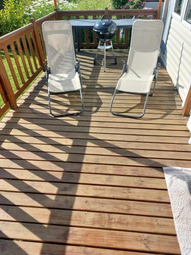 two chairs and a grill on a deck at Camping La Tentation in Renty