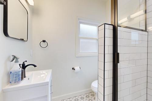a white bathroom with a sink and a mirror at Easy Access to OSU! 'Marvin's Manor' in Stillwater in Stillwater