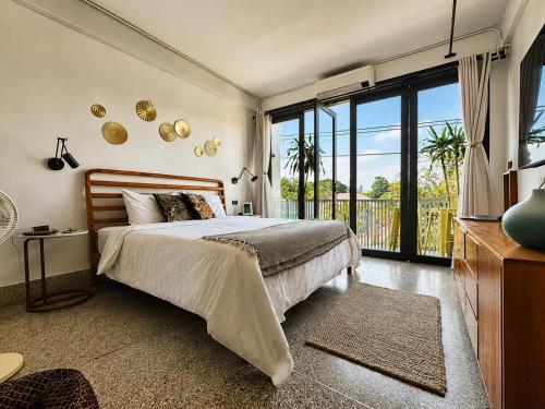 a bedroom with a bed and a large window at Siri Designer 3-Storey Townhouse with Garden and Luxury Amenities in Bangkok