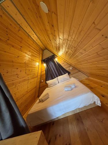 a bed in a room with a wooden ceiling at Twenty 23 Cottages,kazbegi 1 in Kazbegi