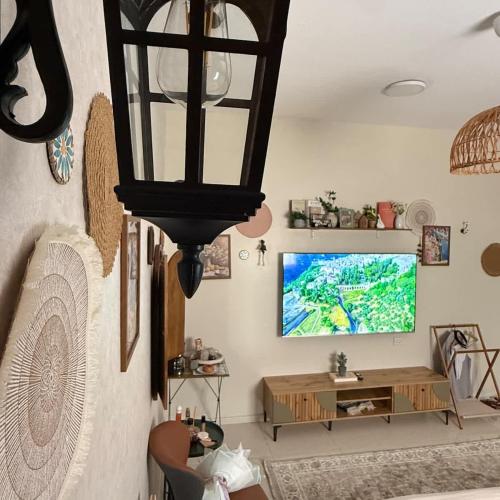 a living room with a large chandelier and a tv at The Italian Studio7 in Dammam