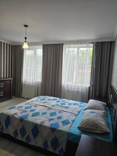 a bedroom with a bed with a quilt on it at Guest House KATO in Poti