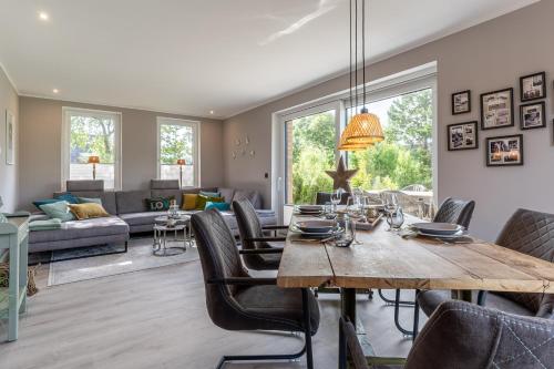 a dining room and living room with a table and chairs at Püppi Hems Huus in Osterhever
