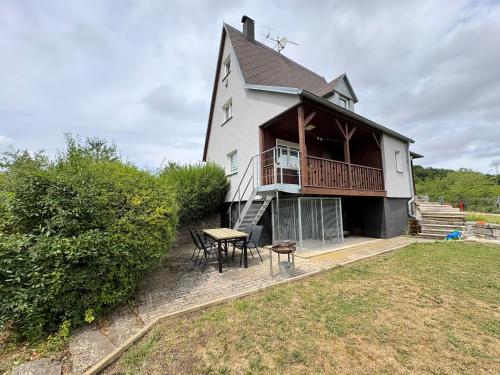 a house with a balcony and a table and chairs at Chata v zátoce - Nechranice in Kadaň