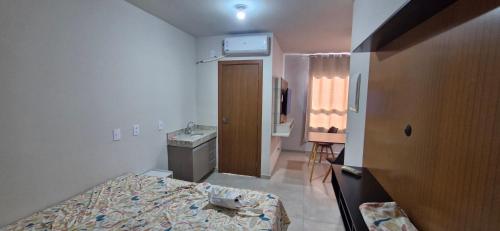 a small room with a bed and a sink at Apartamento Universitário in Uberaba