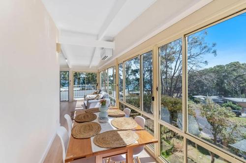 a dining room with a table and some windows at The Loft at Long Beach in Long Beach