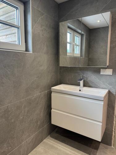 a bathroom with a white sink and a mirror at Maramaa Backyard Bliss in Viljandi