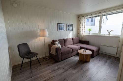 a living room with a couch and a chair at Havnegata Apartments in Vadsø