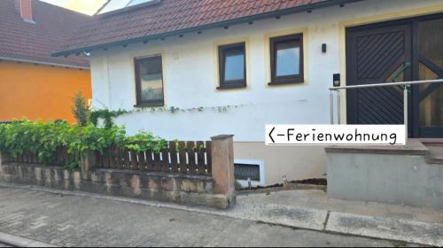 a white house with a fence in front of it at Pfälzerblick Lambrecht- Ferienwohnung mit Garten in Lambrecht