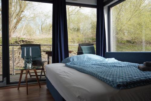 a bedroom with a bed and a large window at Hausboot Stöckte in Winsen