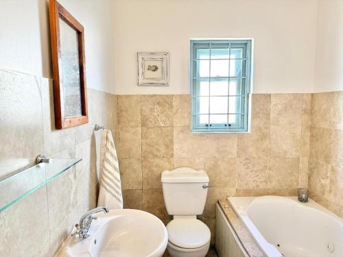 a bathroom with a toilet and a tub and a sink at Rose Pearl in Paternoster