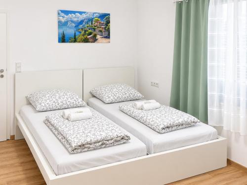 two beds in a room with white walls at 92 City Rooms in Koblenz