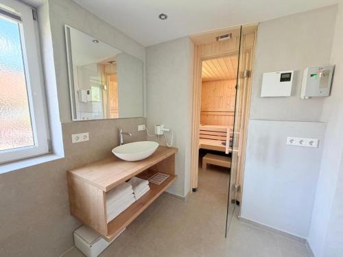 a bathroom with a sink and a mirror at Alpenzeit - Ferienhaus mit Sauna, Garten und Bergblick bei Garmisch-Partenkirchen in Farchant