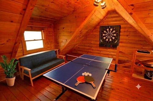 a room with a ping pong table in a cabin at ログハウス SakuraFamiliar in Kawazu