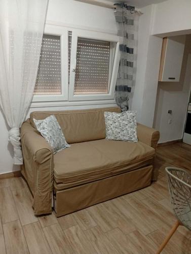 a brown couch in a living room with two pillows at LOUKIA'S HOUSE in Skala Kallirachis