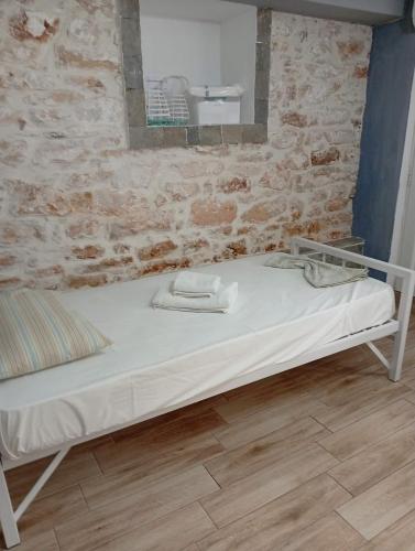 a bed in a room with a brick wall at LOUKIA'S HOUSE in Skala Kallirachis