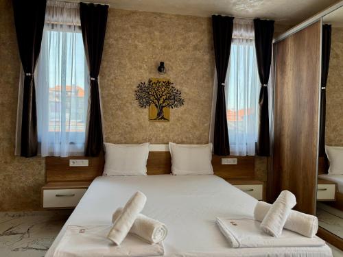 a bedroom with two towels on a bed with windows at Стаи за гости- Maria Elegance in Pavel Banya