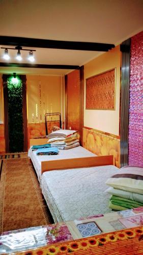 a bedroom with two beds and a wall at Небольшая СТУДИЯ, проспект ЦЕНТРАЛЬНЫЙ 124А, 2 дивана, 2 кресла 3 этаж 9 этажного дома Wi-Fi in Mykolaiv