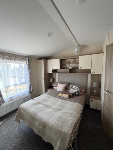 a bedroom with a large bed and a window at Teal - a few steps from the beach in Redcar