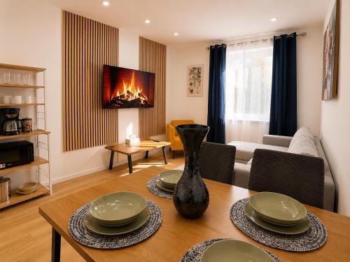 a living room with a table with a vase on it at City Line Koblenz in Koblenz