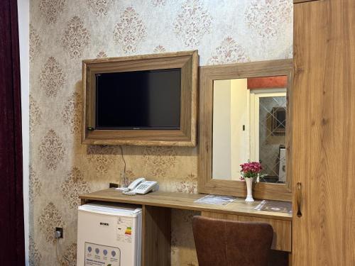 a room with a television on a wall at Modern Palace Hotel in Al Fayşalīyah