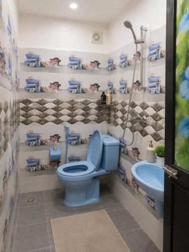 a bathroom with a blue toilet and a sink at Cleopatra Rest House in Nilaveli