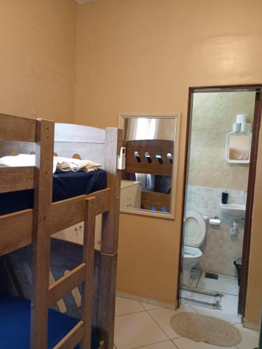 a room with a bunk bed and a bathroom with a mirror at Hostel Mar in São Luís