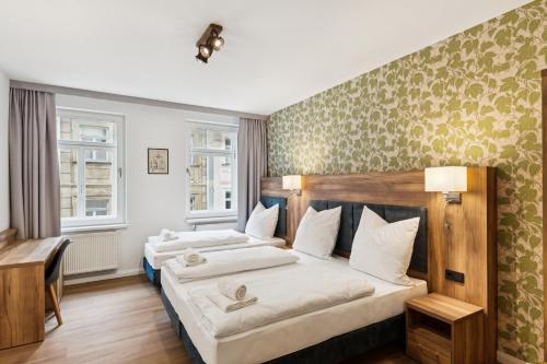 two beds in a room with two windows at Hopfenquartier Altstadt in Bamberg