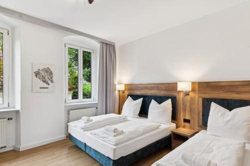 a bedroom with two beds and two windows at Hopfenquartier Altstadt in Bamberg
