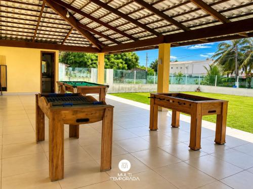 two ping pong tables under a pergola at Casa Ilha do Sol - Vera Cruz/BA in Vera Cruz de Itaparica