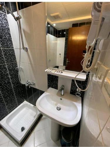 a small bathroom with a sink and a shower at فندق نمبر وان 3 in Al Masfalah