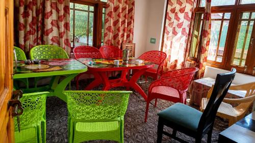 a dining room with a table and colorful chairs at Alpine Hub Gurez in Wāmpor