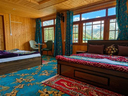 a bedroom with two beds and a window at Alpine Hub Gurez in Wāmpor