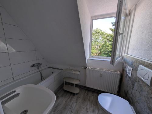 a bathroom with a sink and a toilet and a window at Crew Base Zeltweg in Zeltweg