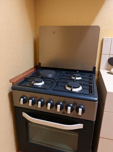 a black stove top oven sitting in a kitchen at Maya Comforts in Ukunda