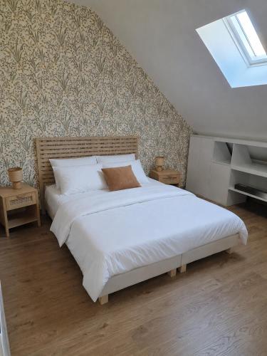 a bedroom with a large white bed in a attic at Cap Ouest in Fécamp