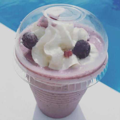 a plastic cup filled with a pink smoothie with berries at The Villa Kazbo in Amami