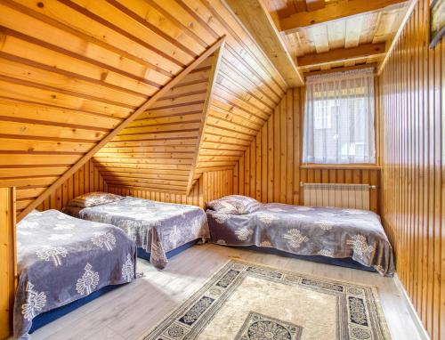 a room with two beds in a log cabin at Domki u Marii- agroturystyka in Bańska Niżna